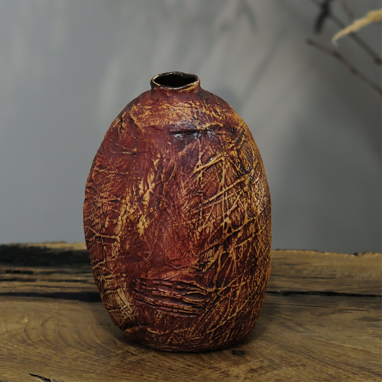 Side view of designer ceramic vase showing unique hand-textured surface and earthy tones