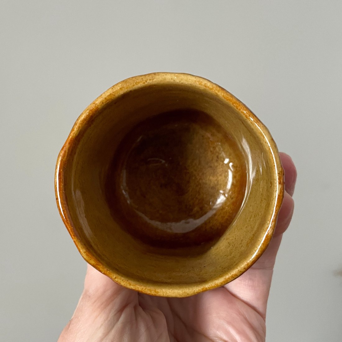 Handmade ceramic drinking cup with earth-tone glaze