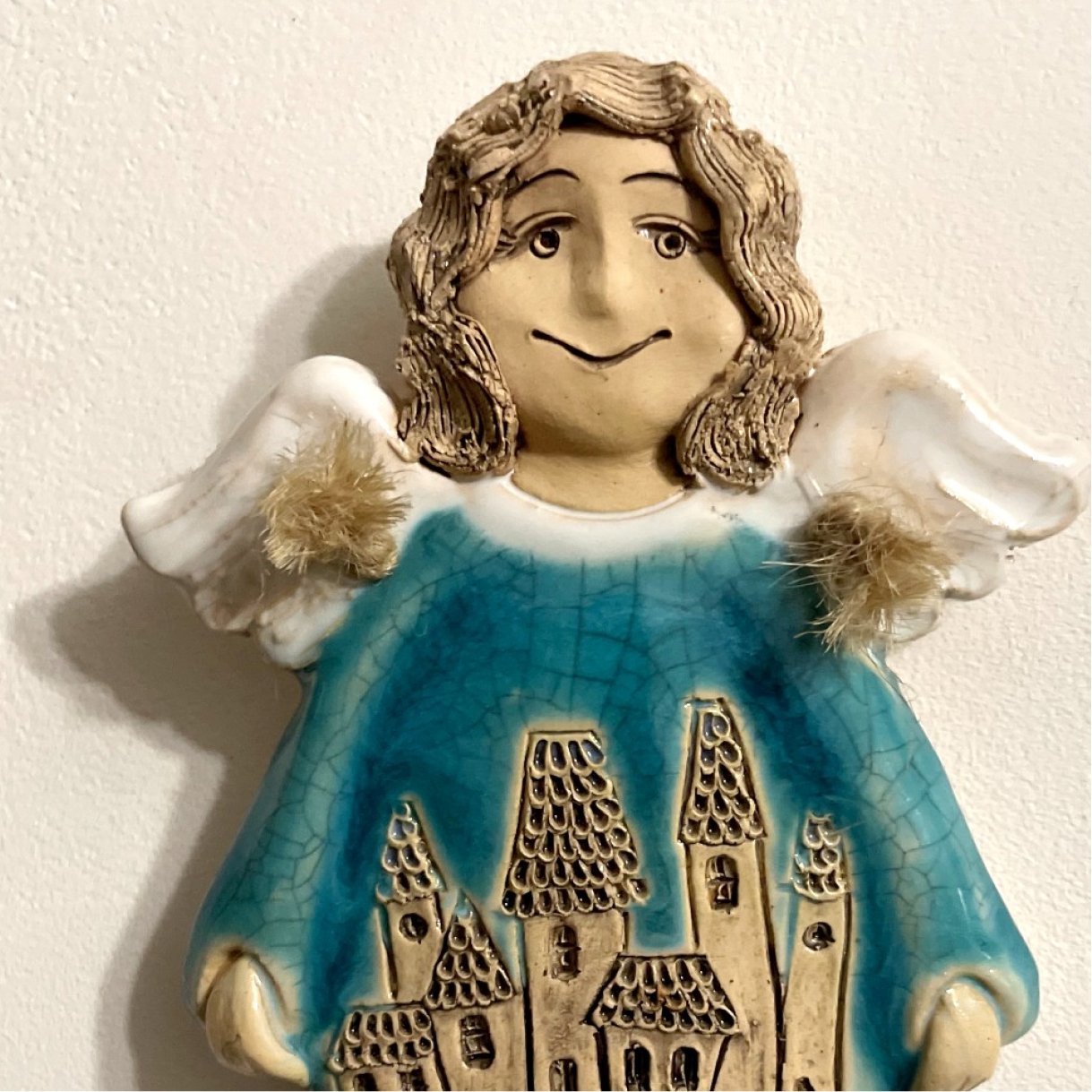 blue ceramic angel wall decor close up