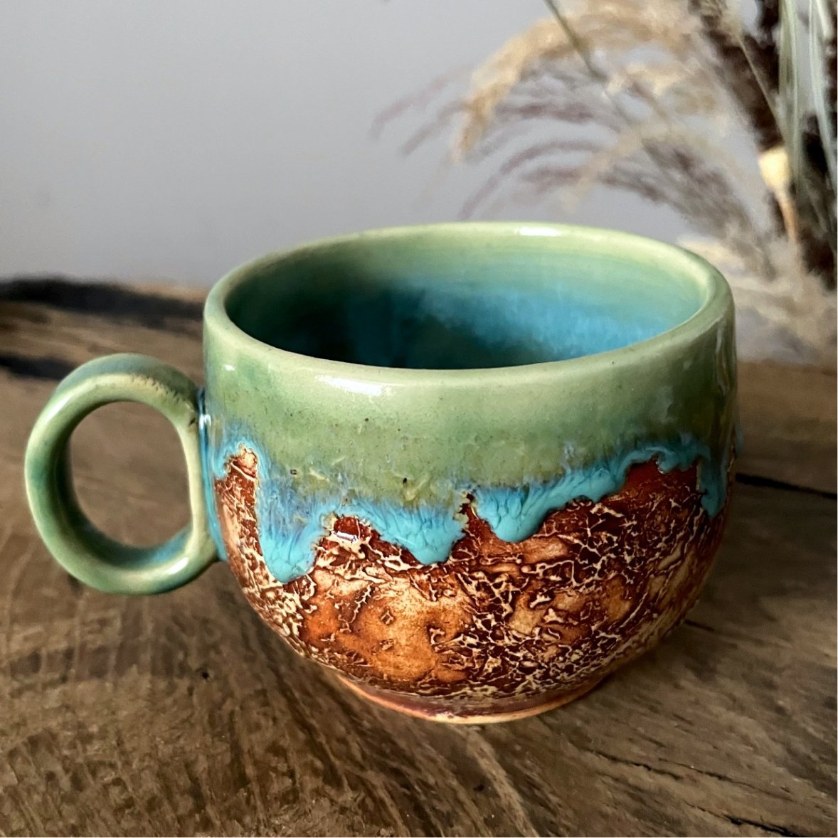 Handmade ceramic cup with green glaze and leaf saucer